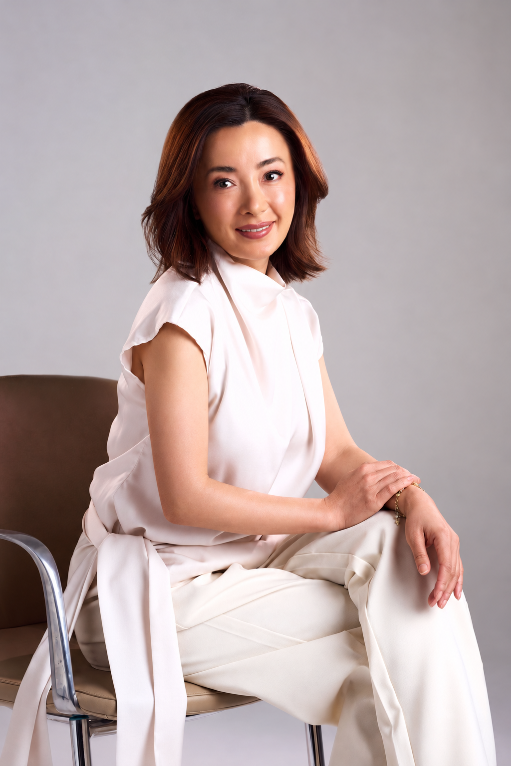 Lyn Shan, founder of SR LUXE, seated in a white outfit