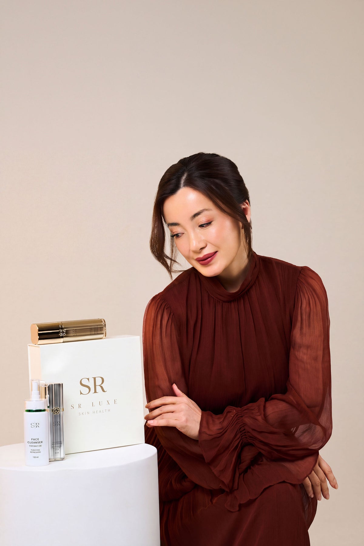 Lyn Shan with the SR LUXE gift box, cleanser, serum and cream